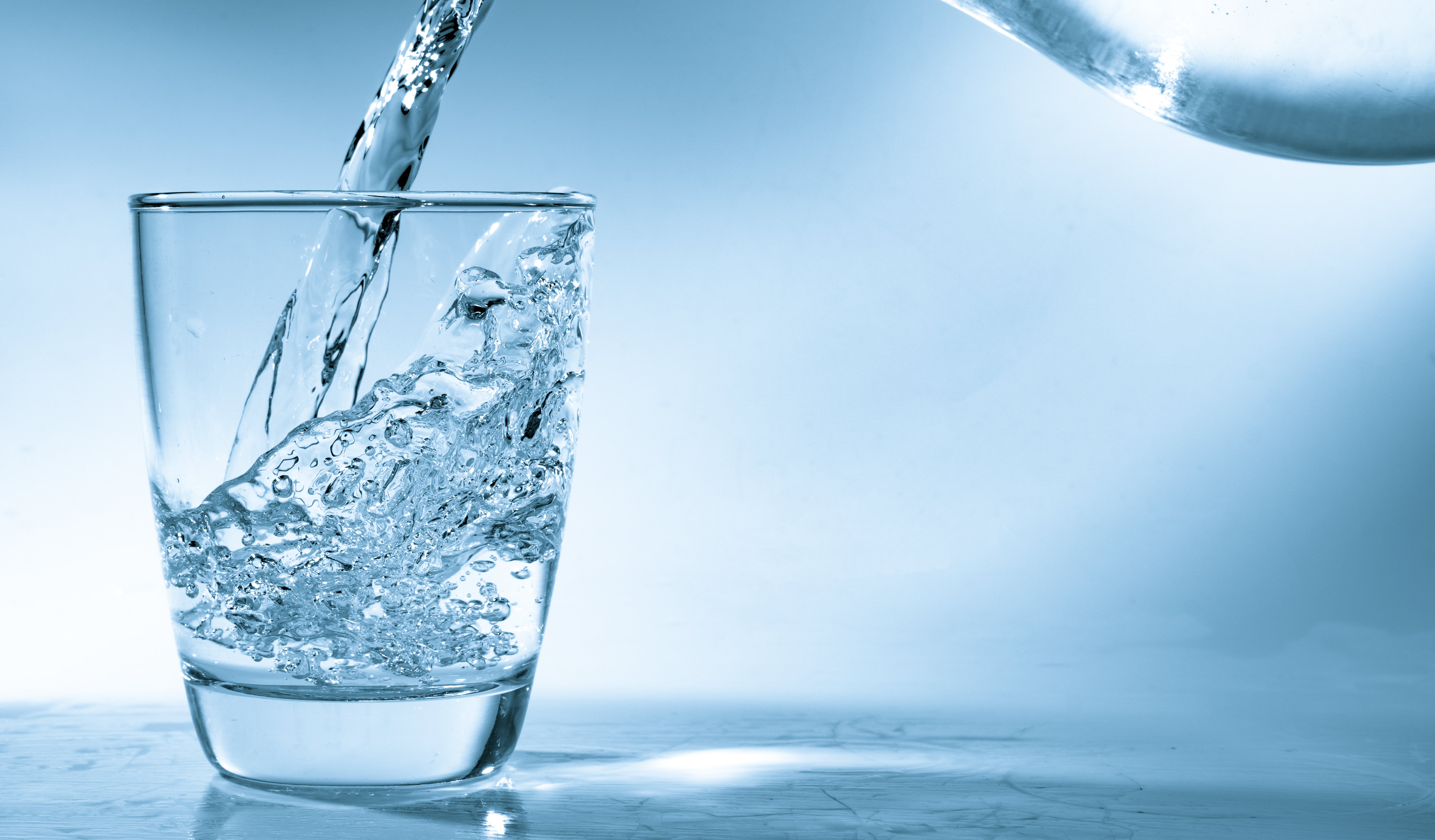 Water being poured into a glass, illustrating the importance of clean, fluoride-free drinking water.